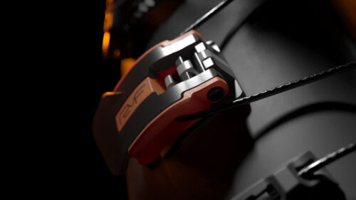 Dettaglio della leva Memory del sistema di chiusura RYF su scarpone da sci, con cavo metallico e meccanismo a regolazione intelligente.